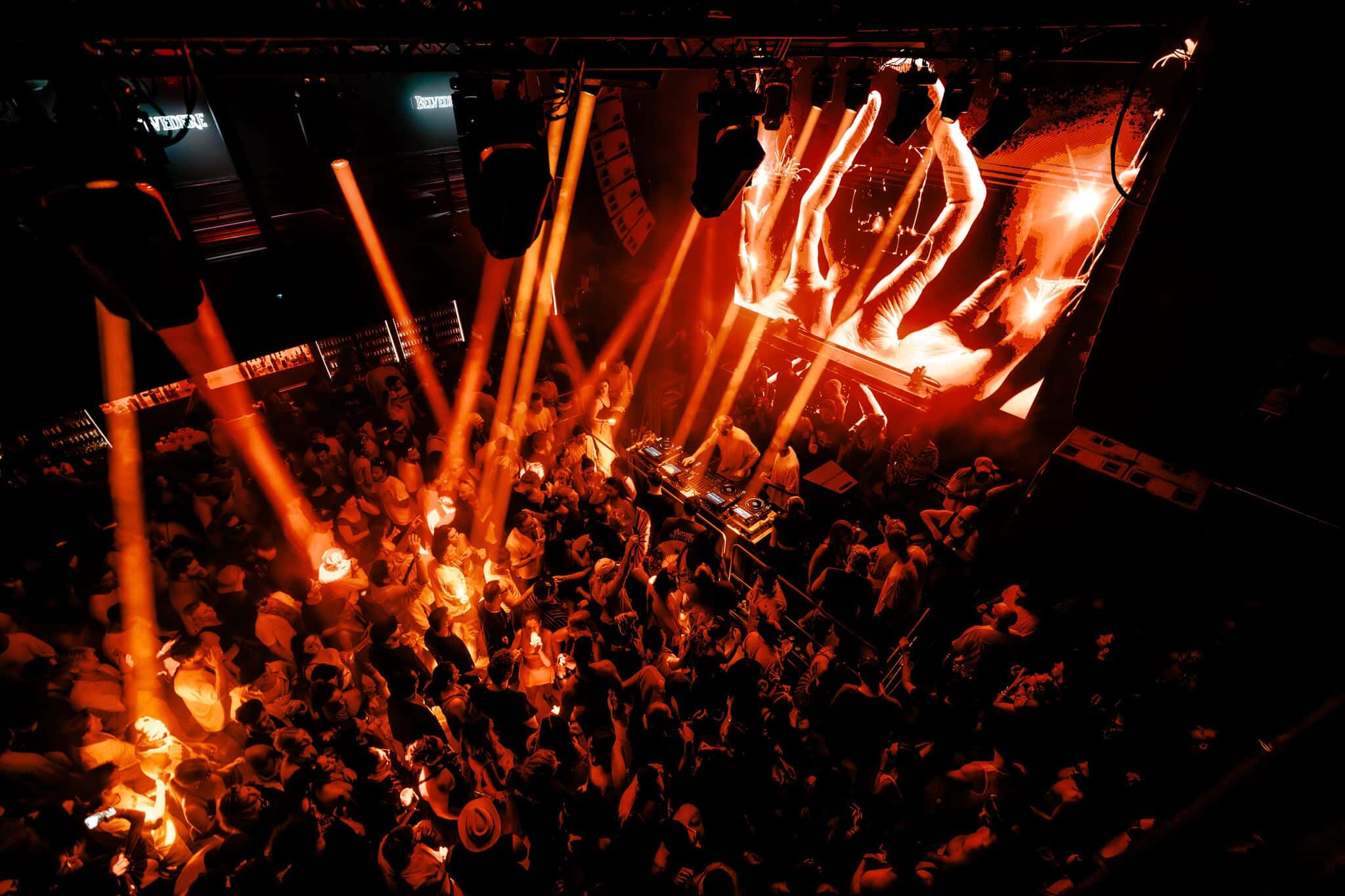 Packed S.A.S.H dancefloor under orange stage lights